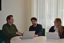 Drie mensen aan vergadertafel met laptops 2